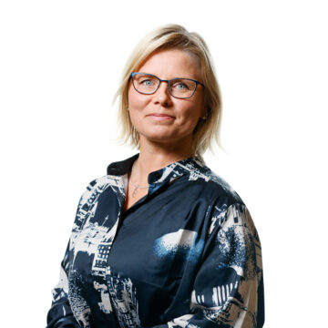 Kvinna i blå skjorta poserar.